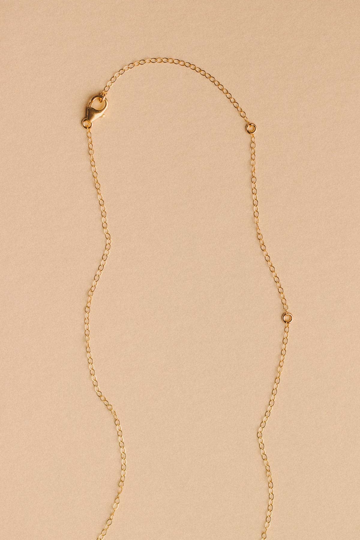Gold necklace on a beige background