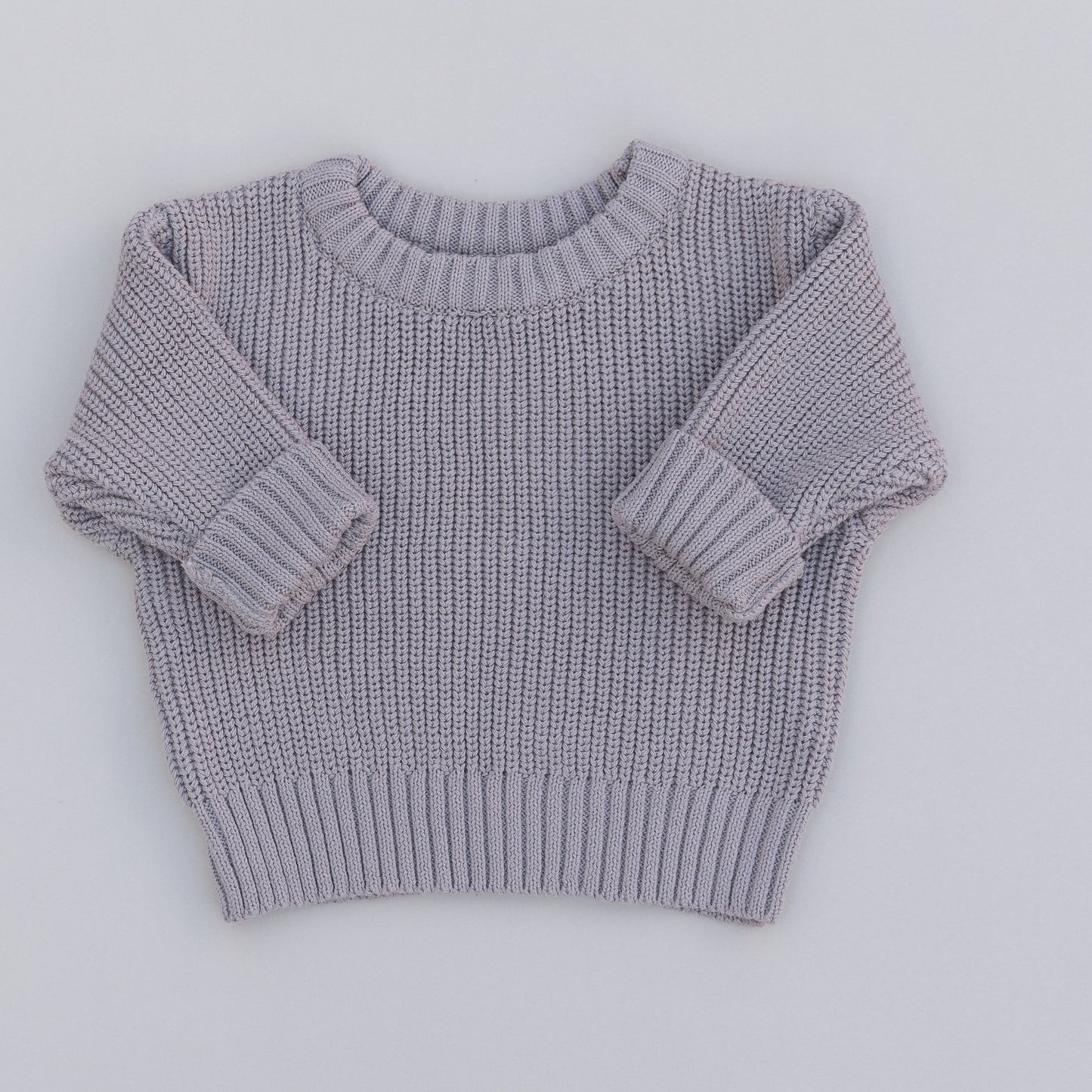 A grey organic cotton knit sweater for babies, displayed against a white background.