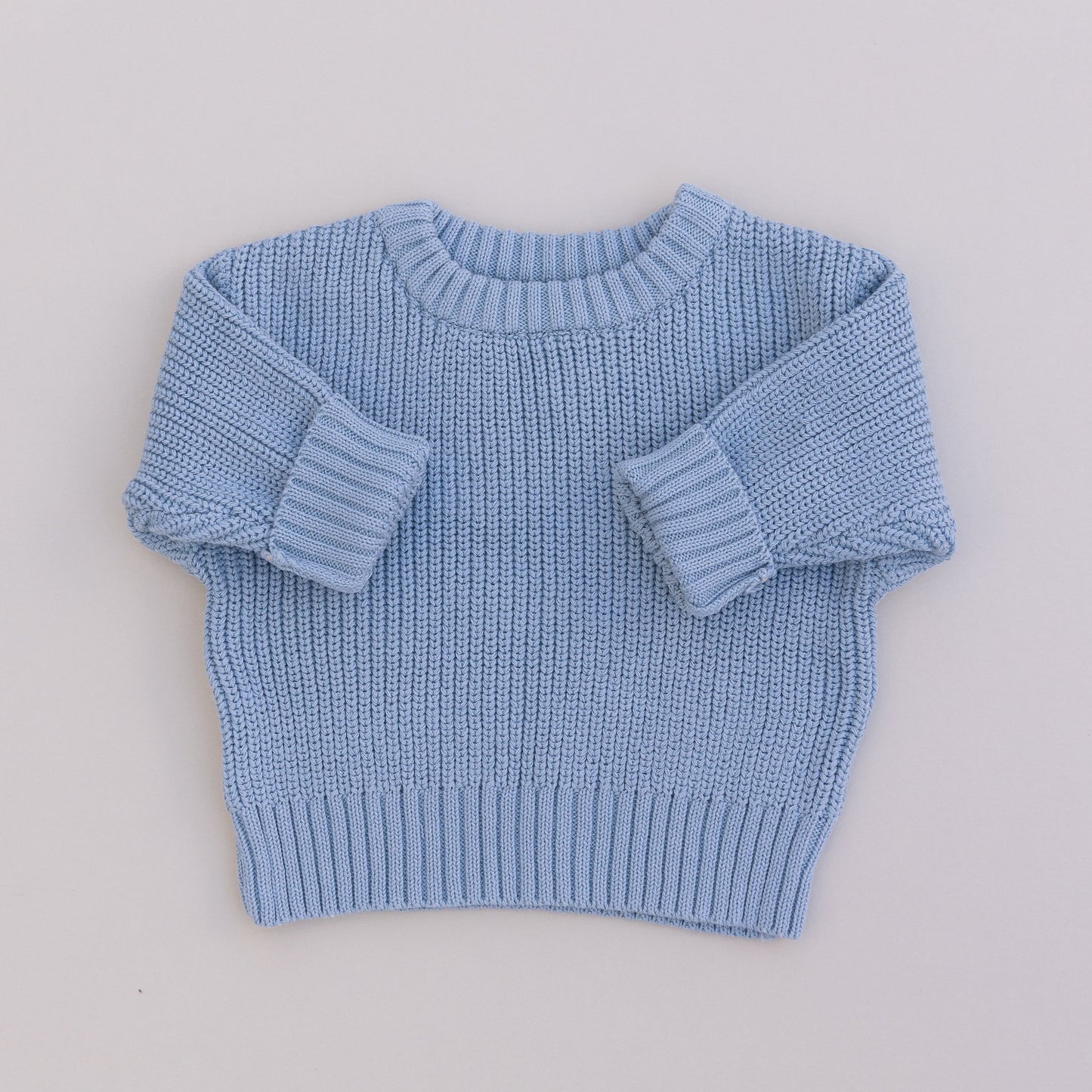 A blue organic cotton knit sweater for babies, displayed against a white background.