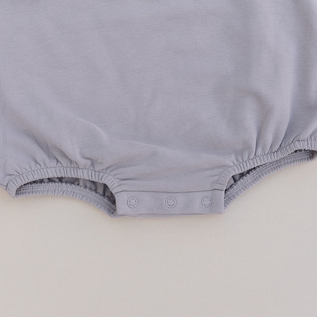 Grey baby romper on a light gray background