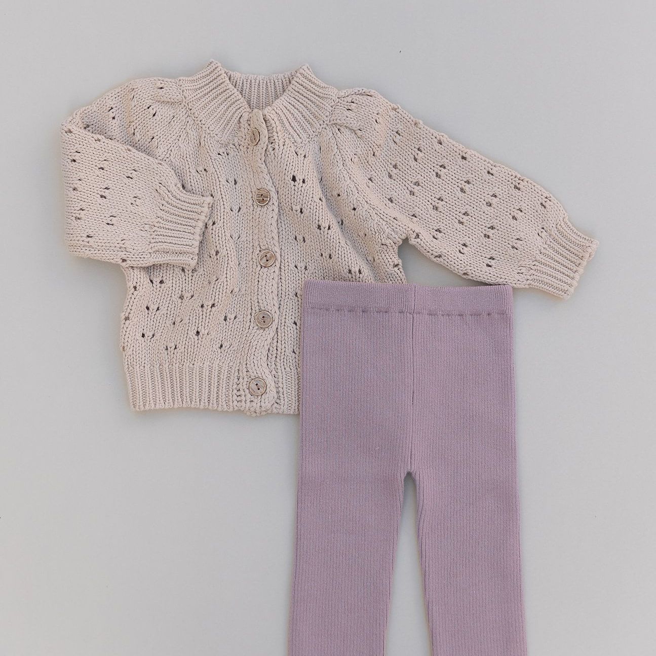 Knit Chunky Baby sweater and mauve pants set on a gray background