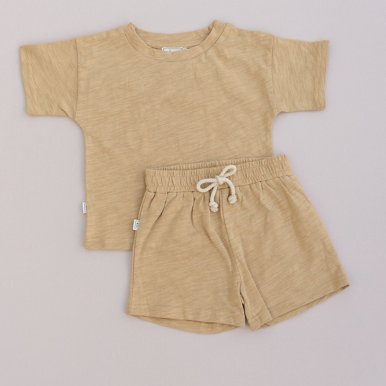 Mustard t-shirt and shorts set on a light gray background