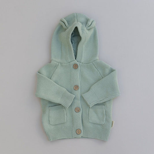 Light green knitted hoodie with buttons and baby bear ears on a gray background