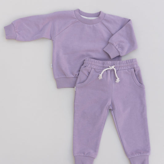 Purple sweatshirt and jogger set on a light gray background